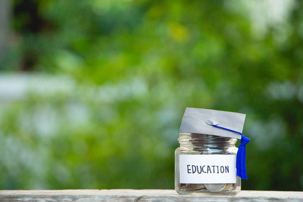 Chapeau de graduation avec pot en verre économiser de l'argent bourse d'études pour l'éducation à l'avenir sur table en bois, vintage, minimal. - Photo, image