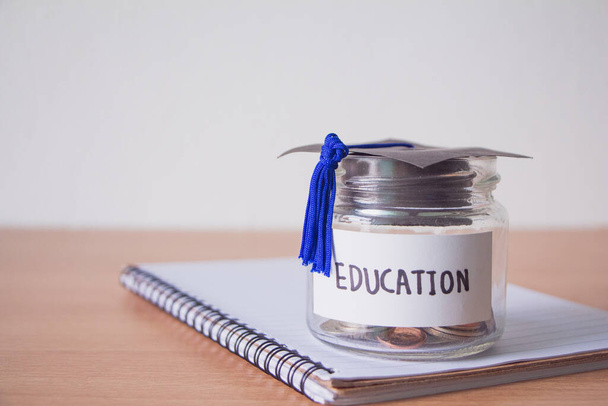 Graduation hat with glass jar saving money scholarship for education in future on wood table,vintage. - Φωτογραφία, εικόνα