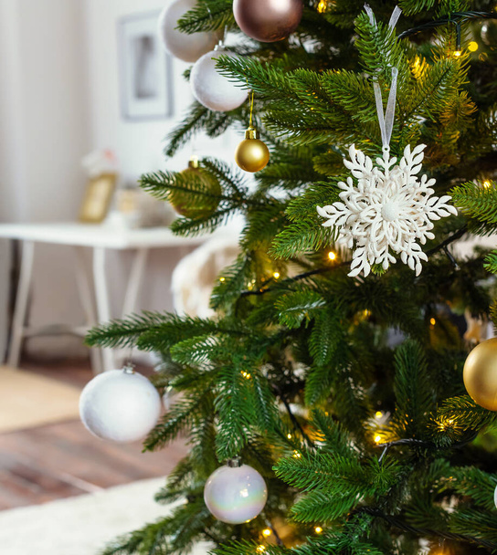 Nagy fehér hópihe dekoráció egy karácsonyfa egy fehér fény szoba a háttérben - Fotó, kép