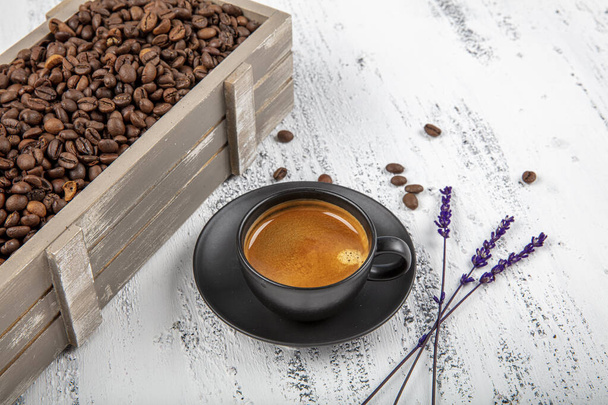 Podwójne espresso. Szklana filiżanka espresso z ziarnem kawy, na starym drewnianym stole. - Zdjęcie, obraz