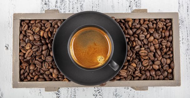 Dvojité espresso. Zavřít espresso skleněný šálek s kávovou zrnkou, na starém dřevěném stole. - Fotografie, Obrázek