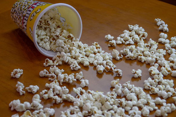 Can of popcorn on a wooden table. Home theater concept. - Photo, Image