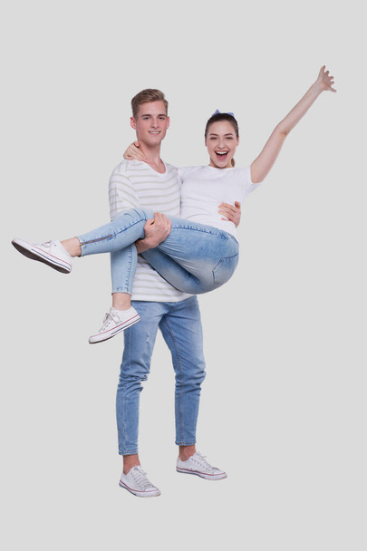 Man Holding Girl in his Arms. Couple Standing Isolated. Lovely Couple Looking to the Camera Girl is Happy Holding Hand Up. Cute Couple, Family, Friends, Lovers Concept. Isolated - Fotografie, Obrázek