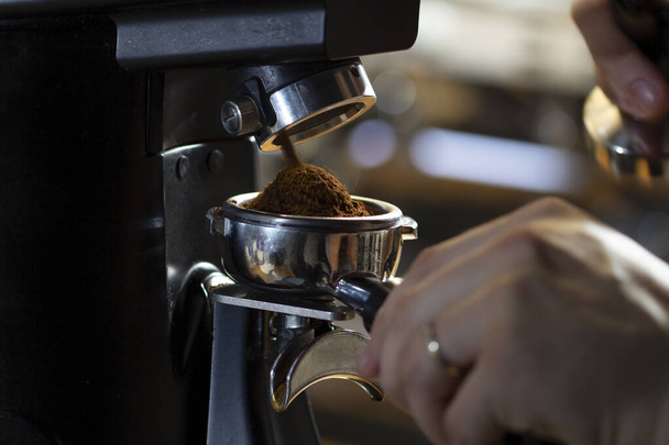 coffee grinder grinding coffee pouring into a portafilter - Zdjęcie, obraz