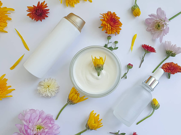 Kozmetik krem, renkli bir arka planda çiçek - Fotoğraf, Görsel