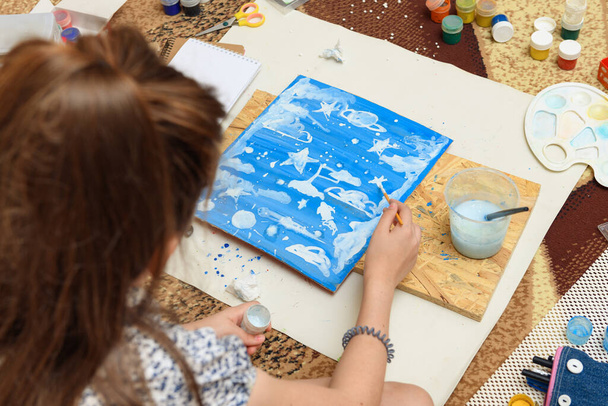 дівчина малює вдома, художнє творіння, створює творчі твори мистецтва з паперу, фарб і пензлів
 - Фото, зображення