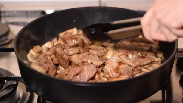 Carne di maiale di cottura con funghi. Chef preparare delizioso pranzo di maiale. - Filmati, video