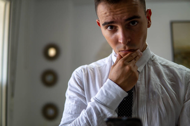 Jovem empresário posa na frente da câmera com uma atitude séria e poderosa - Foto, Imagem