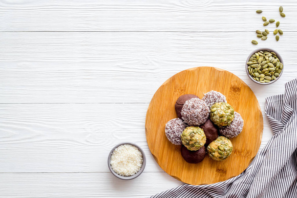 Raw energy balls with coconut and pumpkin seeds, top view - Photo, image