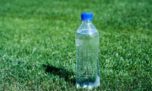 healthy drink. global environment conservation. plastic garbage need recycle. fresh and clean. feel thirsty. pure natural drinking. mineral vitamins. water bottle on green grass. sport and fitness - Fotó, kép
