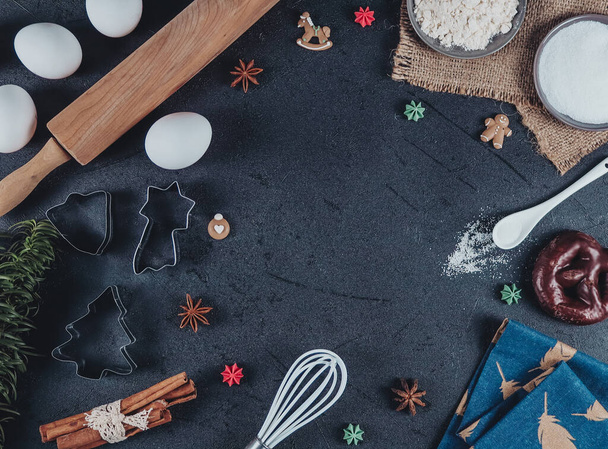 посуд та інгредієнти для випічки печива розташовані в рамці на чорному тлі з місцем для тексту посередині, вид зверху крупним планом
 - Фото, зображення
