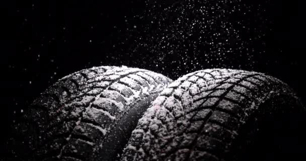 Χειμερινά ελαστικά αυτοκινήτων και βροχή χιονιού σε μαύρο φόντο, 4K βίντεο αργής κίνησης - Πλάνα, βίντεο