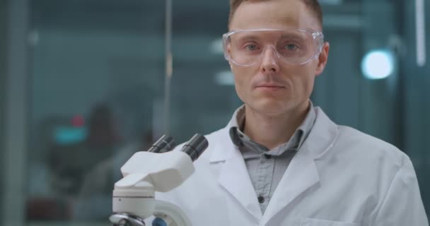 assistant de laboratoire masculin souriant en laboratoire, regardant la caméra, scientifique et expert médico-légal - Séquence, vidéo