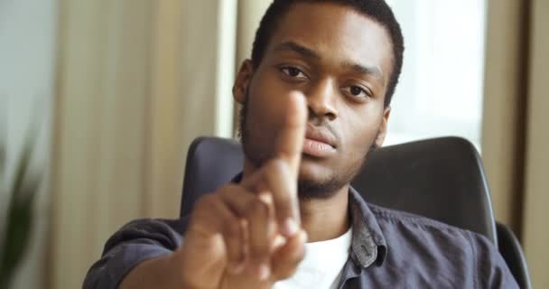 Afro amerikkalainen liikemies freelance yrittäjä istuu pöydässä toimistossa kotona ravistamalla sormeaan paheksuttavasti ele erimielisyyttä kielto osoittaa kehon kieli vihaa ärsytystä tyytymättömyys - Materiaali, video