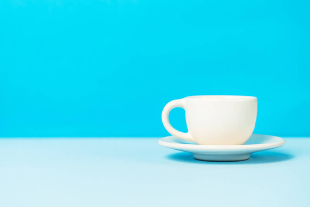 White cup of coffee on the blue background with copy space - Foto, imagen