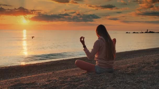Жінка медитує над морем перед заходом сонця
 - Кадри, відео