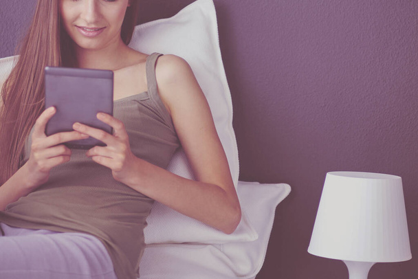 Woman sitting on the floor using a digital tablet - Foto, Bild