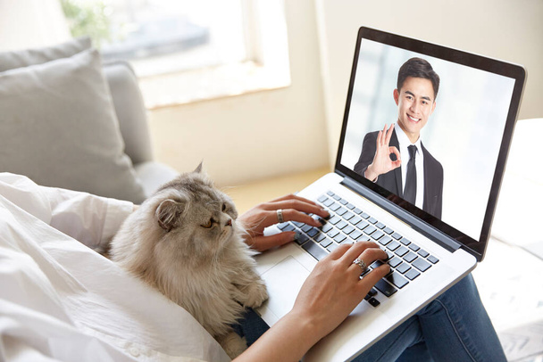 jonge aziatische zakenvrouw werken thuis vergadering met collega online via video gesprek met behulp van laptop computer - Foto, afbeelding