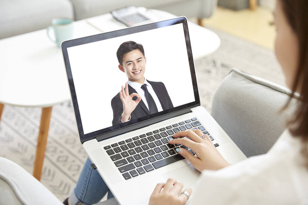jovem asiático mulher de negócios trabalhando a partir de casa reunião com colega online via chat de vídeo usando computador portátil - Foto, Imagem