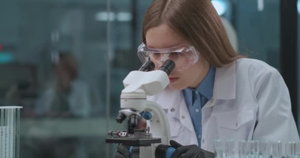 експерт з судової експертизи тестує докази в лабораторії, переглядає зразки в мікроскопі, жінка-технік досліджує аналіз
 - Кадри, відео