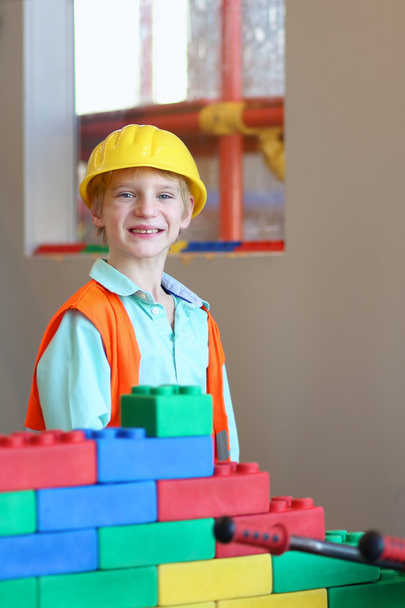 Boy building a house with big plastic construction bricks - Photo, Image
