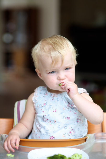 Дівчина годує смачними свіжоприготованими брокколі
 - Фото, зображення