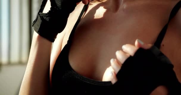Close view of beautiful bust in black tank top of sporty fitness kobieta z manicure w izolowanym gorącym studio pod słońcem rano. Oszałamiająca pierś młodego sportowca w sportowej koszuli odpoczywającej po treningu. - Materiał filmowy, wideo