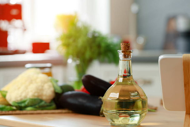 Glass bottle of oil on kitchen counter - Foto, afbeelding