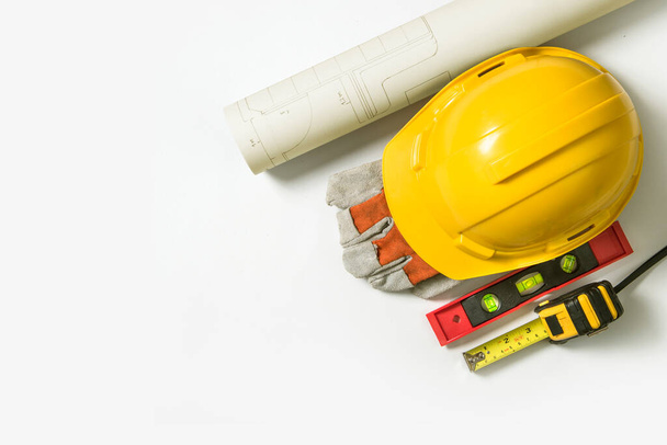 Beyaz arka plan üzerinde zamanında çalışmaya hazırlanan inşaat işçileri ve araçları için sarı güvenlik kaskı. - Fotoğraf, Görsel