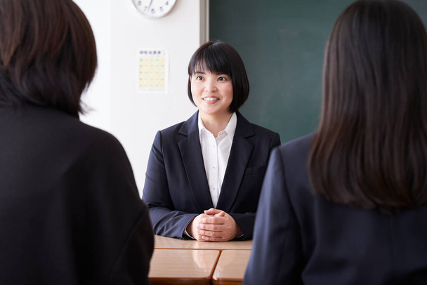 Una profesora japonesa realizando una entrevista de tres vías en su aula - Foto, Imagen