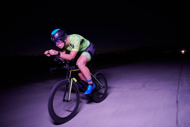 triathlon athlete riding bike fast at night - Fotoğraf, Görsel