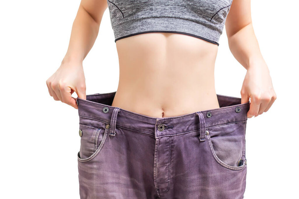 fitness, dieta, perdita di peso e concetto di persone - giovane donna sportiva magra in pantaloni oversize - Foto, immagini