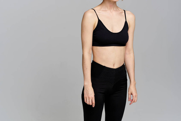 Sporty woman in leggings on a gray background is engaged in fitness Copy Space - Foto, Bild