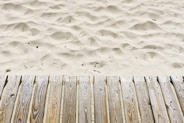 Pasarela de madera con tablones sobre arena blanca de playa. Vista de ángulo alto.  - Foto, imagen