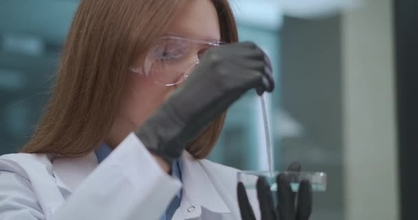 νεαρή γυναίκα φαρμακοποιός αναπτύσσει και δοκιμάζει νέο φάρμακο στο ιατρικό εργαστήριο, φαρμακευτική βιομηχανία - Πλάνα, βίντεο