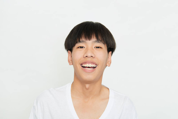 Horizontal shot of a handsome young guy with Brown eyes positive expression, being praised by someone, dressed casually, isolated white studio background - Photo, Image