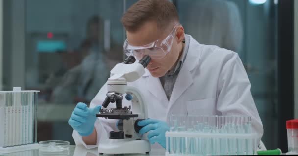 генный инженер изучает анализ в лаборатории, изучает в микроскопе, эксперименты с ДНК - Кадры, видео