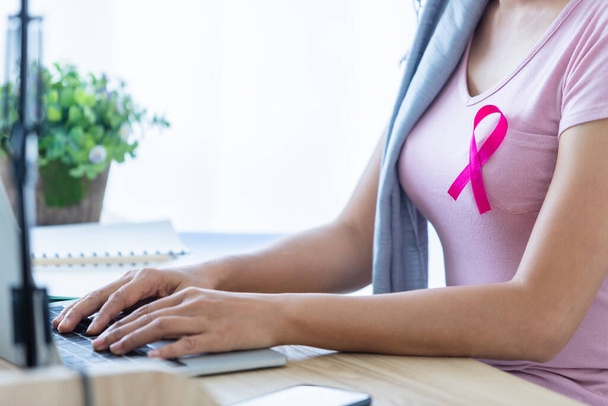 a asian women disease mammary cancer patient with pink ribbon wearing headscarf After treatment to chemotherapy with working business at laptop in office at home,medicine concept - Fotografie, Obrázek