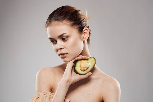 Beautiful brunette naked shoulders avocado in clean skin hand - Fotografie, Obrázek