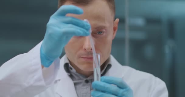 férfi laboratóriumi technikus teszteli és elemzi az új gyógyszer gyógyítására coronavirus, mintát vesz a kémcsőből - Felvétel, videó