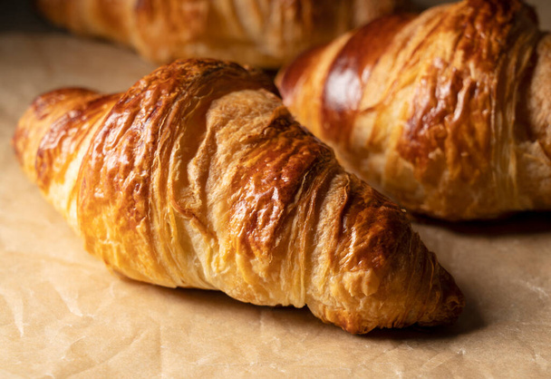 Close-up of a croissant placed on kitchen paper. Image of croissant - Foto, immagini