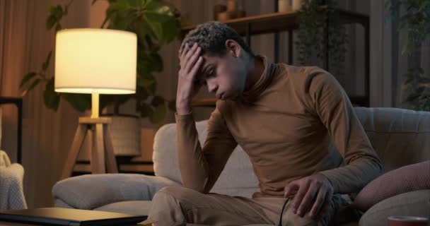 Muž trpící depresí sedí v noci na gauči - Záběry, video