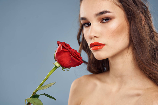 femme avec une rose dans ses mains épaules nues soirée maquillage lèvres rouges - Photo, image