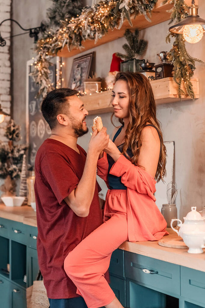 A young couple celebrates Christmas in a cozy country house concept of Winter holidays and Family holidays. Festive atmosphere. - Foto, Bild