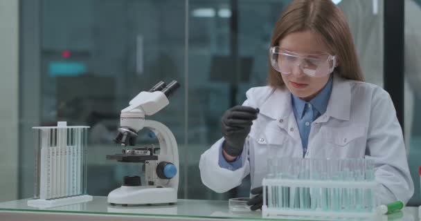 laboratório estudante de medicina, mulher jovem está trabalhando com tubos de ensaio com produtos químicos e análises médicas - Filmagem, Vídeo