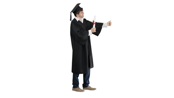 Graduation student showing thumb up on white background. - Foto, afbeelding