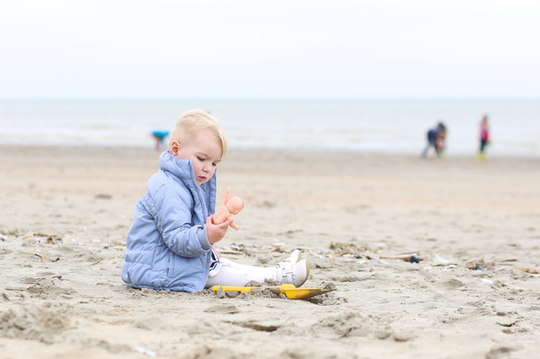 Baby girl plays on sandy beach - Photo, image