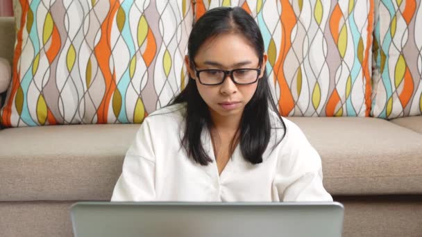 Vážná žena v bílém tričku nosí brýle, bolí ji hlava ze stresu, pracuje doma na laptopu přesčas. Koncept práce z domova během epidemie koronaviru. - Záběry, video