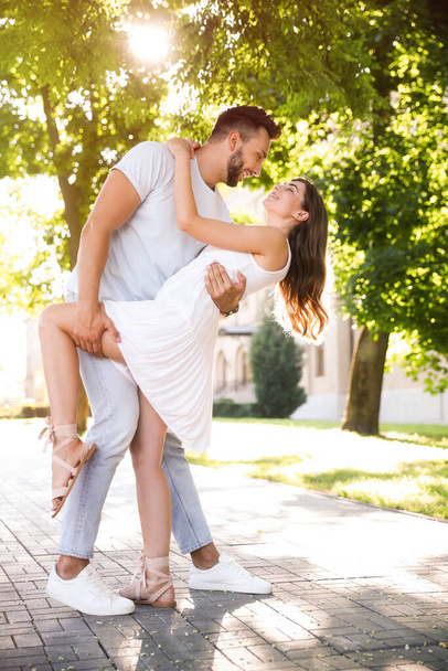 Lovely young couple dancing together in park on sunny day - Foto, immagini