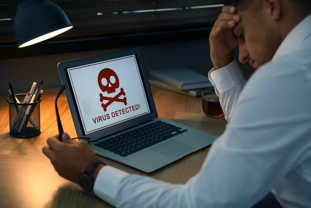 Man in front of laptop with warning about virus attack at workplace - Φωτογραφία, εικόνα